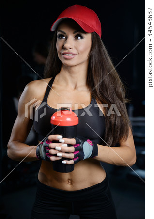 Sexy athletic young girl takes sport nutrition Sexy athletic young girl takes sport nutrition 34543632