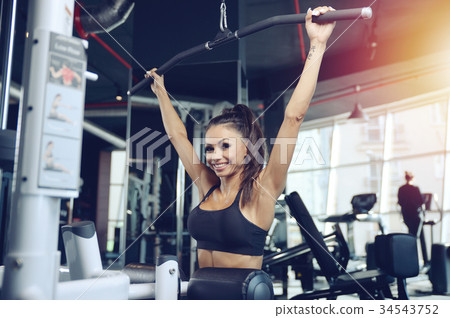 Sexy athletic young girl training back in gym Sexy athletic young girl training back in gym 34543752