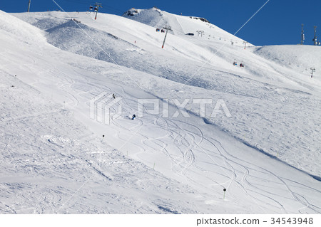 Snowboarders downhill on ski slope 34543948
