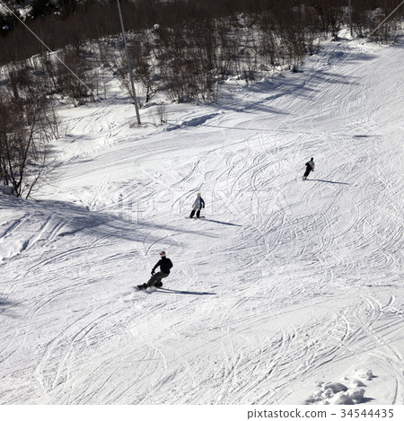 Skier and snowboarders on ski slope at winter day Skier and snowboarders on ski slope at winter day 34544435