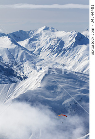 Paragliding at snow mountains in haze 34544481