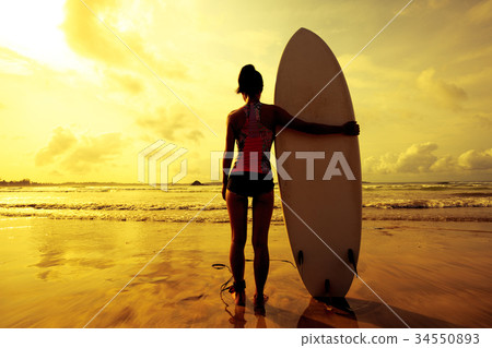 Young woman surfer with surfboard ready to surf Young woman surfer with surfboard ready to surf 34550893
