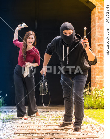 Beautiful woman throwing her shoes to the thief. 34552848