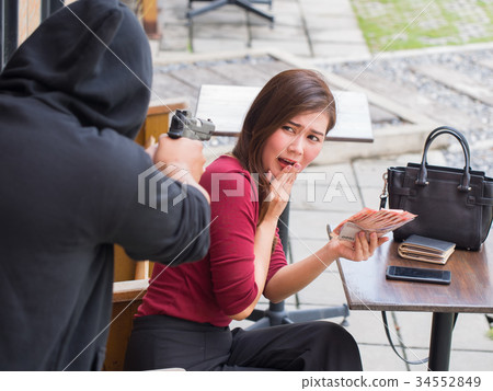 The thief intimidating with gun for extortion. 34552849