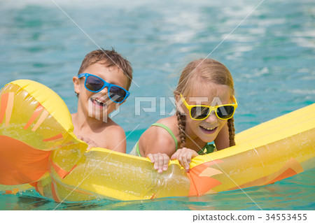 Two happy children playing on the swimming pool at the day time. Two happy children playing on the swimming pool at the day time. 34553455