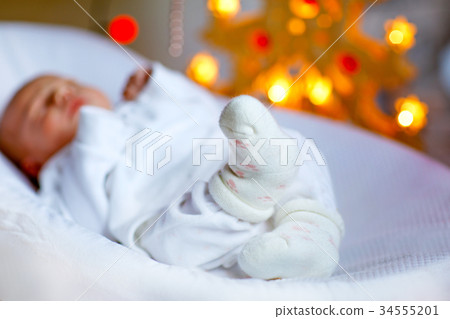 One week old newborn baby girl sleeping near 34555201