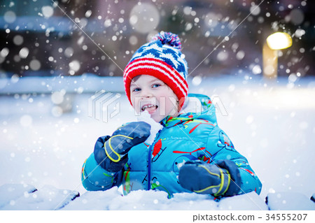Happy kid boy having fun with snow in winter Happy kid boy having fun with snow in winter 34555207