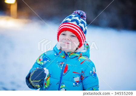 Happy kid boy having fun with snow in winter Happy kid boy having fun with snow in winter 34555209