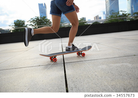 young woman skateboarder riding skateboard at city young woman skateboarder riding skateboard at city 34557673