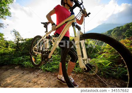cyclist carrying mountain bike climbing on trail cyclist carrying mountain bike climbing on trail 34557682