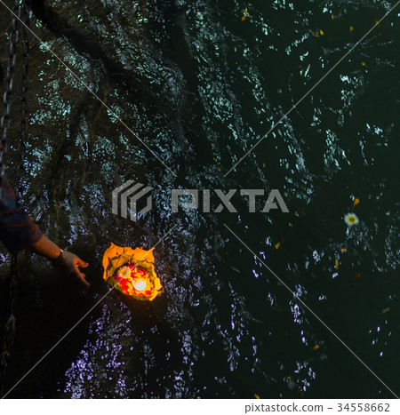 floating burning candles on the Ganges River. 34558662