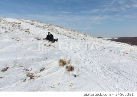 Man riding a mountain on a sled in winter Man riding a mountain on a sled in winter 34563381