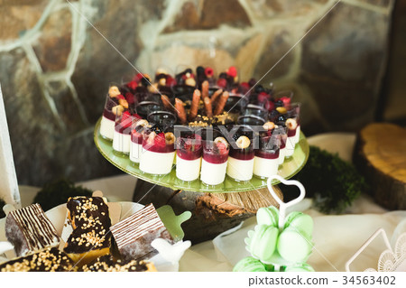 Delicious and tasty dessert table with cupcakes Delicious and tasty dessert table with cupcakes 34563402