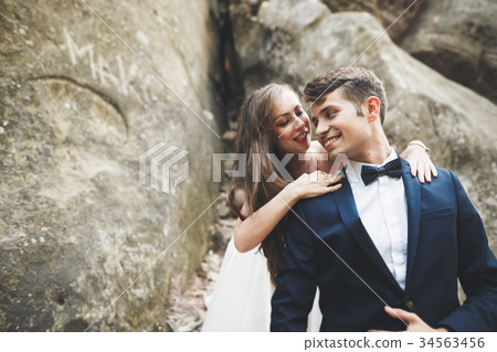 Happy wedding couple kissing and hugging near a Happy wedding couple kissing and hugging near a 34563456