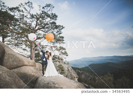 Beautiful happy young wedding couple posing on a Beautiful happy young wedding couple posing on a 34563495