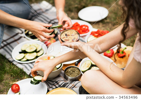 Unrecognizable teenagers camping and cooking. 34563496