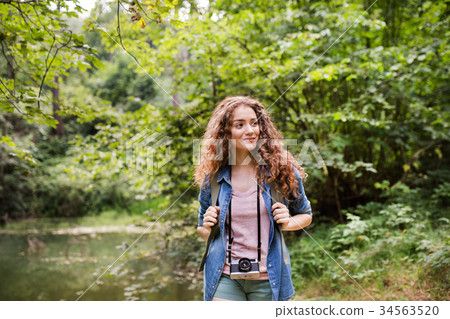 Teenage girl hiking in forest. Summer vacation. 34563520