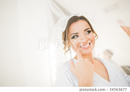 Gorgeous bride in robe posing and preparing for 34563677