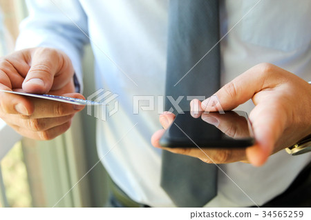 business man entering data of a credit card. 34565259