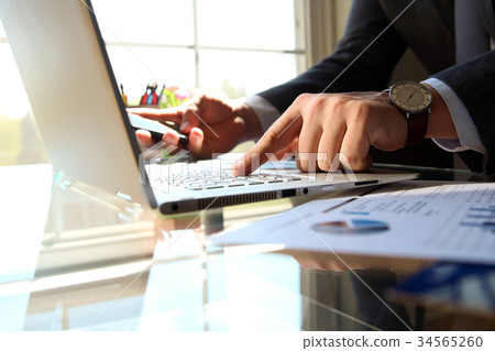 Man working and analyzing on a graphs on a laptop Man working and analyzing on a graphs on a laptop 34565260