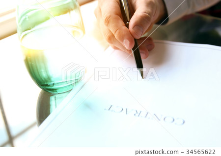 business man is signing a contract in the office business man is signing a contract in the office 34565622