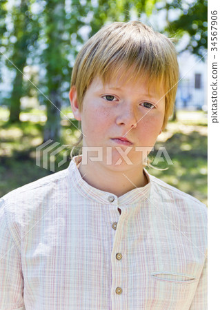 Portrait of serious boy in park Portrait of serious boy in park 34567906