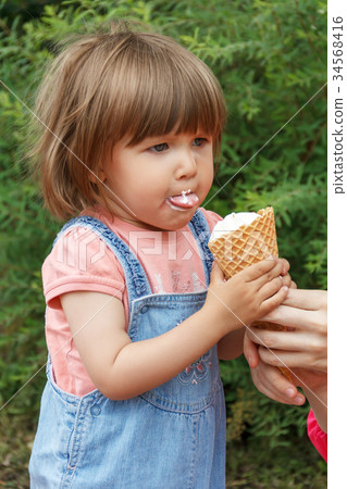 Baby are eating icecream with put out tongue Baby are eating icecream with put out tongue 34568416