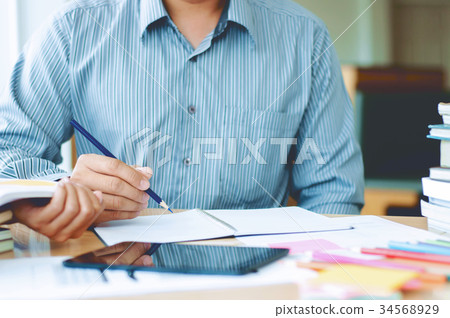 Two students reading a book or doing homework 34568929