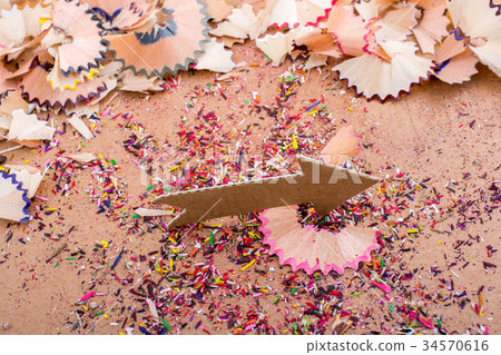 Arrow cut out of paper amid pencil shavings Arrow cut out of paper amid pencil shavings 34570616