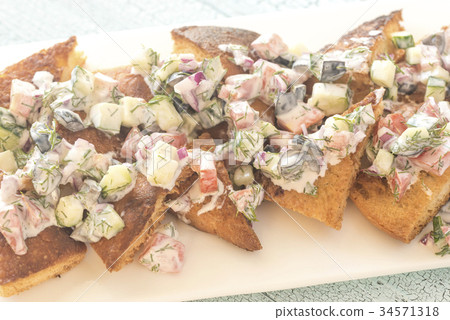 Greek pita nachos with vegetable topping Greek pita nachos with vegetable topping 34571318