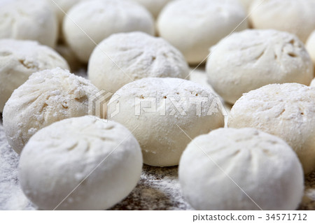 Khinkali on wooden plate with flour. Pelmeni 34571712
