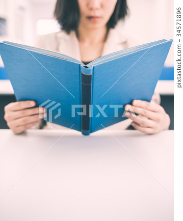 A woman reading a book A woman reading a book 34571896