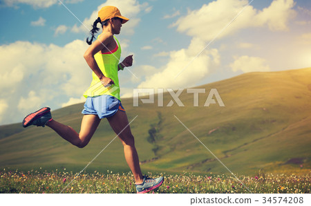 fitness woman trail runner running on mountain   34574208
