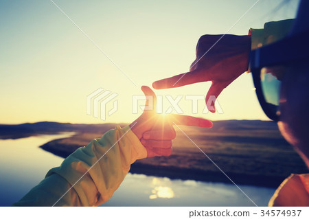 hands making a frame sign over sunset sky hands making a frame sign over sunset sky 34574937