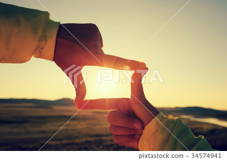 Human hands making a frame sign over sunset sky 34574941