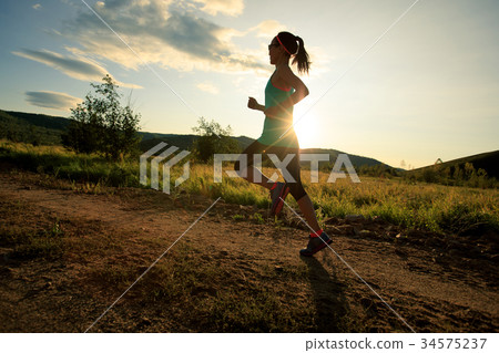 trail runner woman running on forest trail trail runner woman running on forest trail 34575237