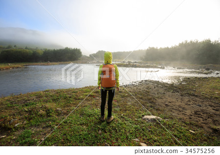 Tourist with backpack in the sunrise riverside 34575256