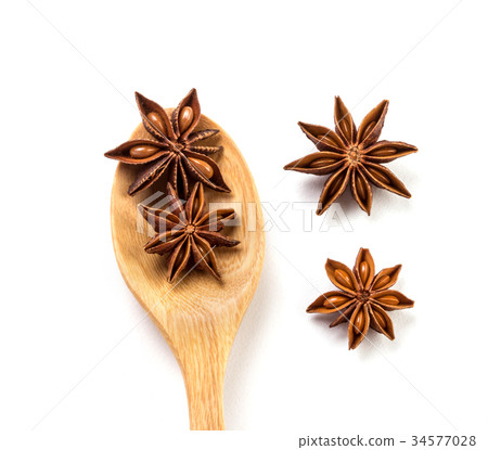 brown star anise spice in wooden spoon isolated 34577028