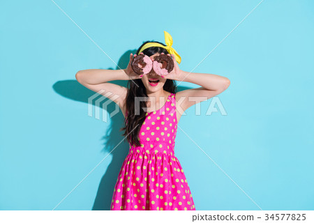 girl wearing dress standing on blue background 34577825