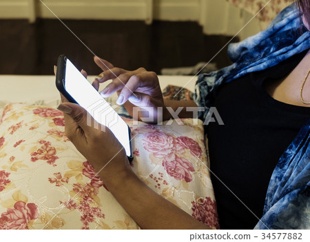 Hands using smartphone sitting on bed sleeping at  34577882