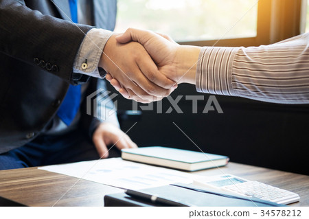Two confident business man shaking hands during a meeting in the Two confident business man shaking hands during a meeting in the 34578212