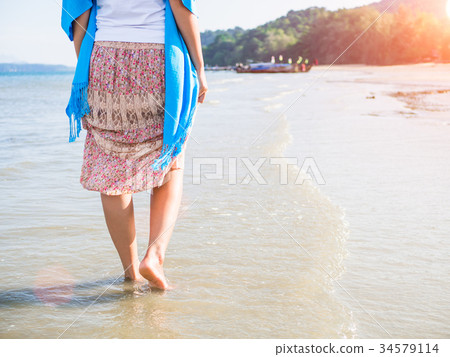 woman walking on sand beach. woman walking on sand beach. 34579114