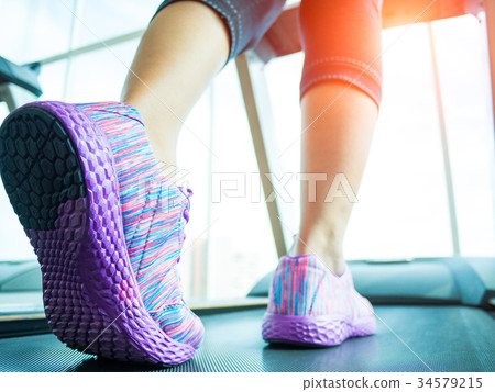 Woman step and running on the treadmill 34579215