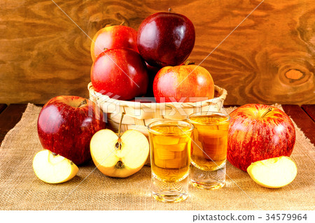 Schnapps drinks and apples in the wicker basket 34579964