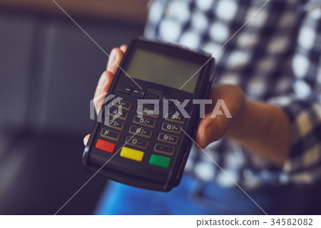 Man holding a payment terminal Man holding a payment terminal 34582082