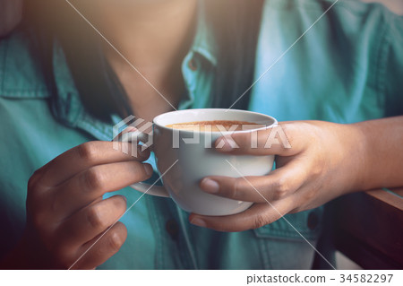 Asian woman holding hot coffee.selective focus Asian woman holding hot coffee.selective focus 34582297