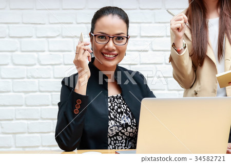 Two business women are discussing work. Two business women are discussing work. 34582721