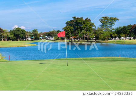 Red flag and sand bunker at golf course 34583385