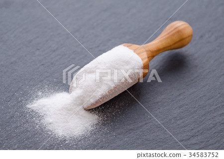 baking soda in a wooden scoop on black 34583752