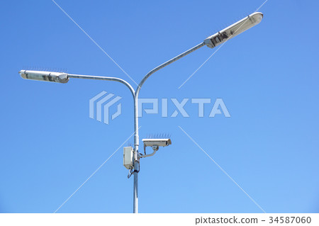 surveillance camera on light pole in parking lot 34587060